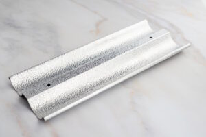 Textured galvanized metal corner bead with pre-punched holes on a marble surface