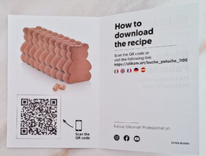 Folded brochure page with a pink, sculpted pastry on the left and bold 'How to download the recipe' text on the right, plus a QR code below.