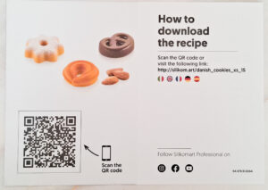 Assorted cookies on a white background beside a 'How to download the recipe' instruction and a QR code to scan for the recipe.