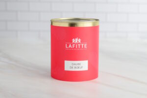 Red metal can with a gold lid, featuring a white label that reads 'DAUBE DE BOEUF' on a pinkish-red background.