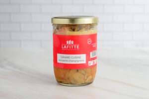 Glass jar of Lafitte canned duck with mushrooms; red label reads 'CANARD CUISINÉ aux petits champignons'.