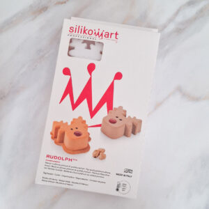 Silikomart Professional Rudolph 100 packaging with red abstract figures on a white box and cookie mold images nearby.