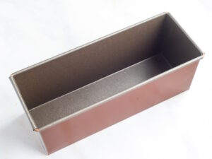Rectangular loaf pan with a dark nonstick interior, empty and on a light surface.