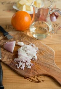 Fischfilet mit Orangen-Butter-Sauce Kabeljau Rezept Schritt 5 Schalotten Würfeln Auf Holzbrett 206x300