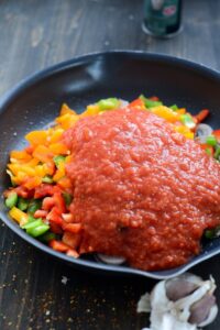Piperade mit Eiern (Piperade aux oeufs) Piperade Rezept Schritt 6 Tomatensauce Über Paprika In Pfanne