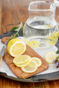 Wasser mit Gartenkräutern und Blüten aromatisieren Kräuterwasser Rezept Schritt 6 Zitronenscheiben Auf Holzbrett 200x300